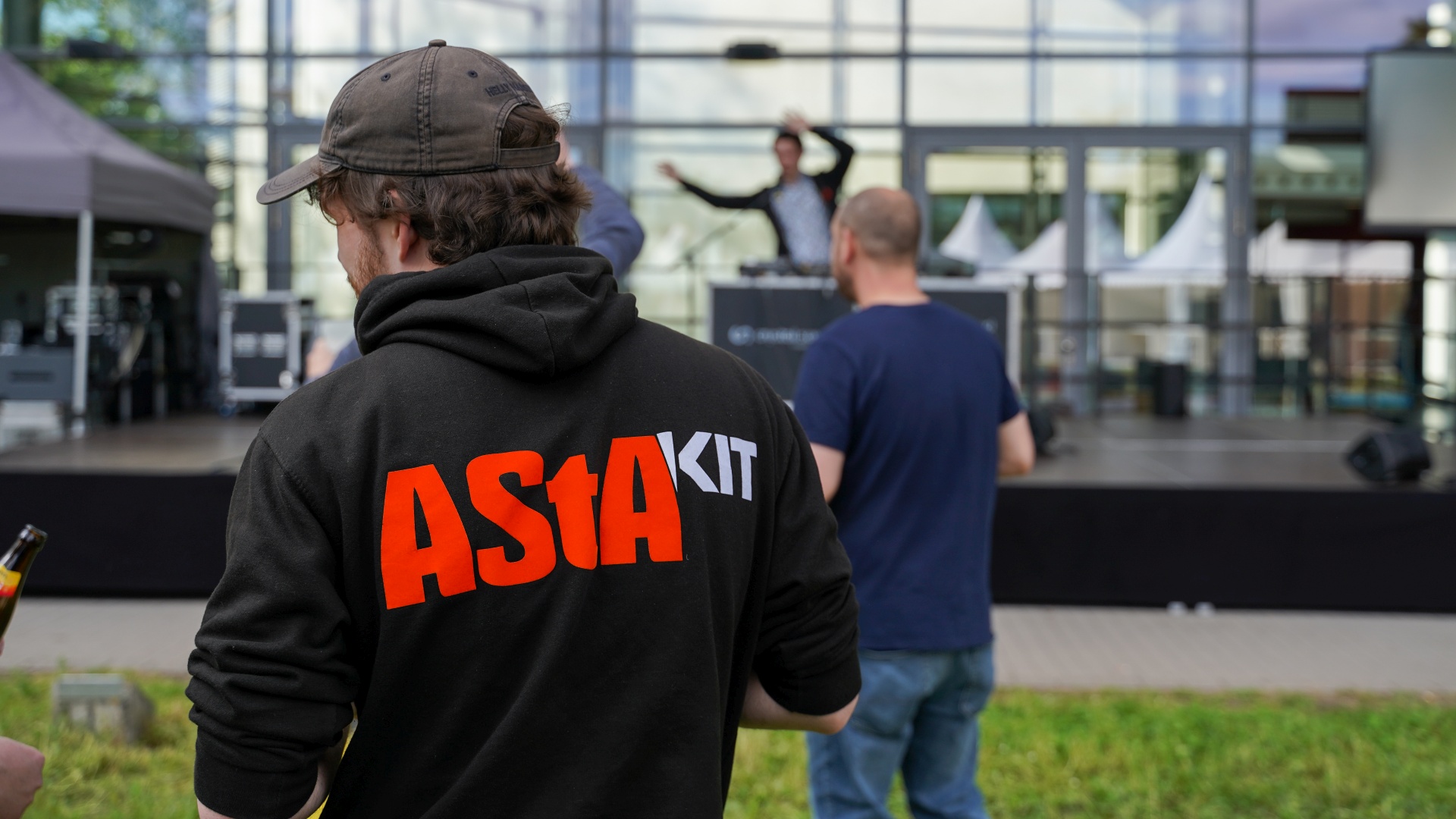 Person mit "AStA KIT"-Pullover bei einer Veranstaltung im Freien vor dem Audimax.